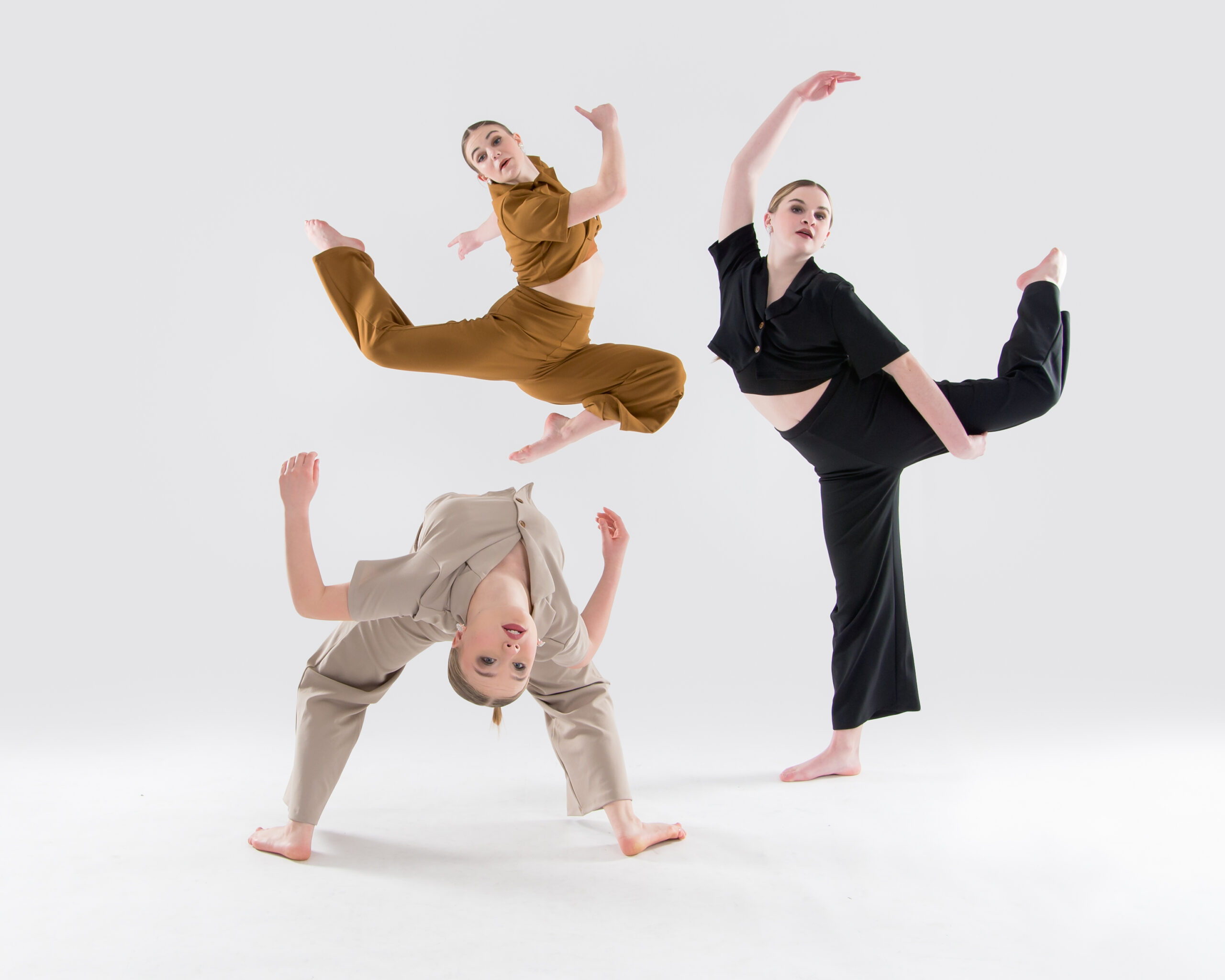 3 dancers, each doing a different pose, in a formation that feels circular