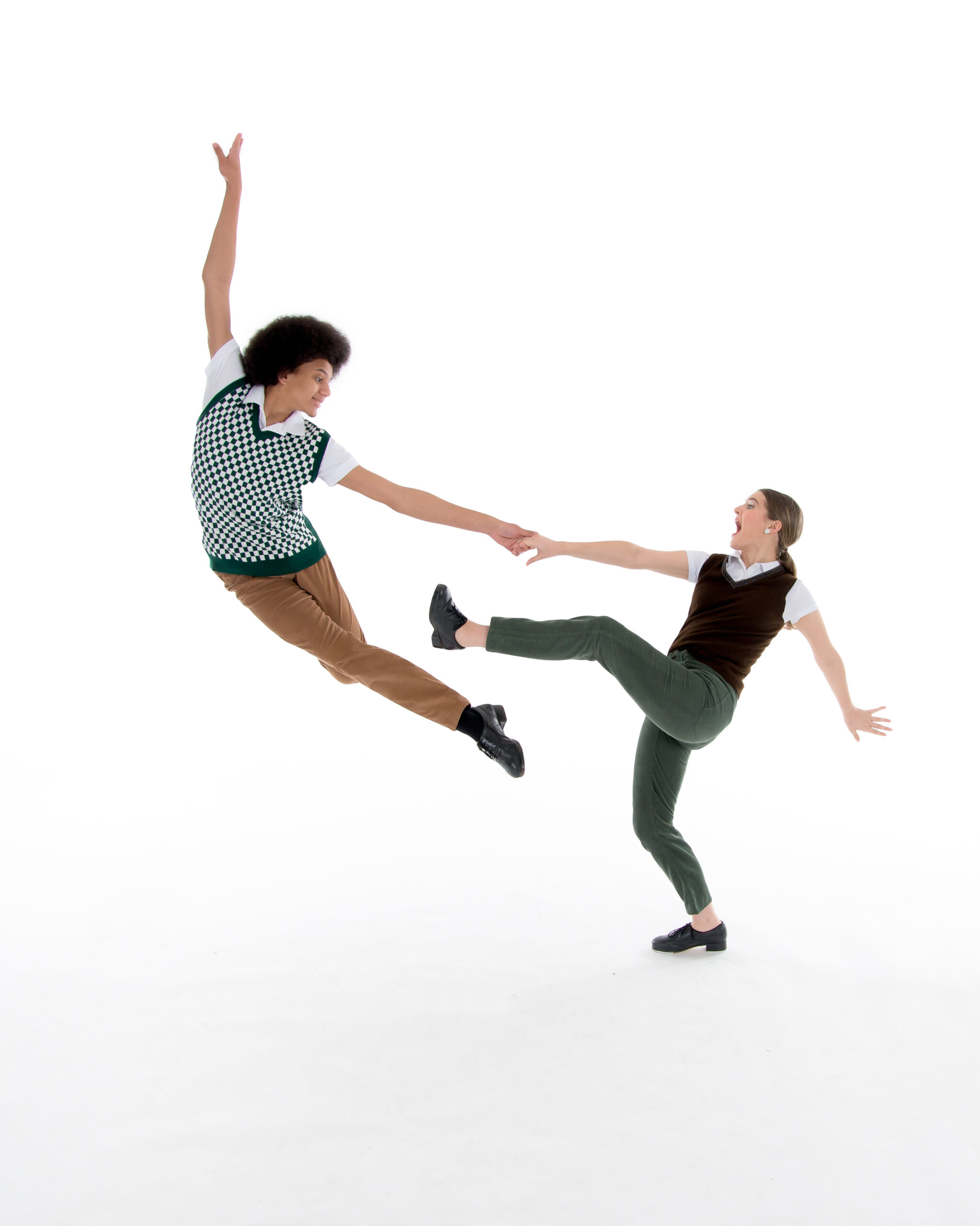 Female and male tap duet - male dancer is jumping while female dancer is holding his hand and leaning back in an attitude to show off her shoe.