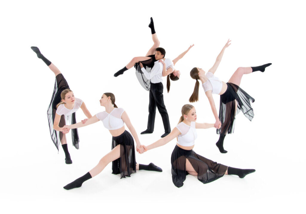 Dance group photo including a two person lift, arabesques, and attitudes. Students in white shirts and black skirts/pants.